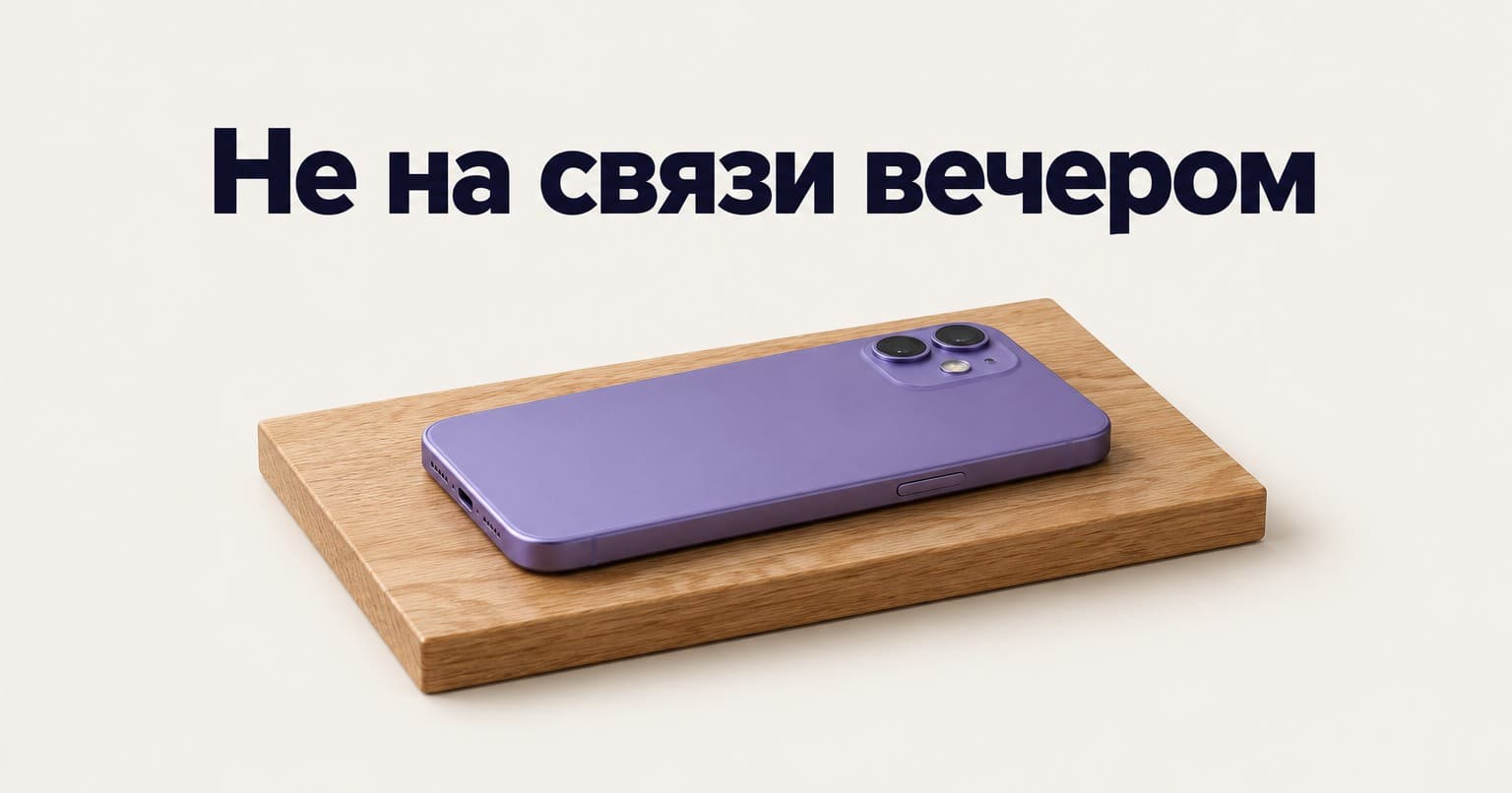 Фиолетовый смартфон экраном вниз на деревянной подставке и надпись «Не на связи вечером»